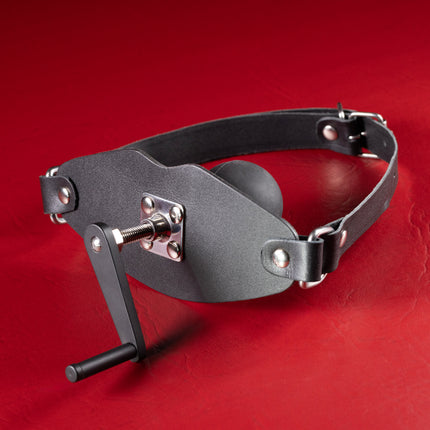 Stuff It Ball Gag with Hand Crank, black leather mouth panel with crank handle and silicone ball